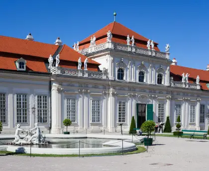 Lower Belvedere with a red-tiled roof and ornate windows under a bright blue sky.
