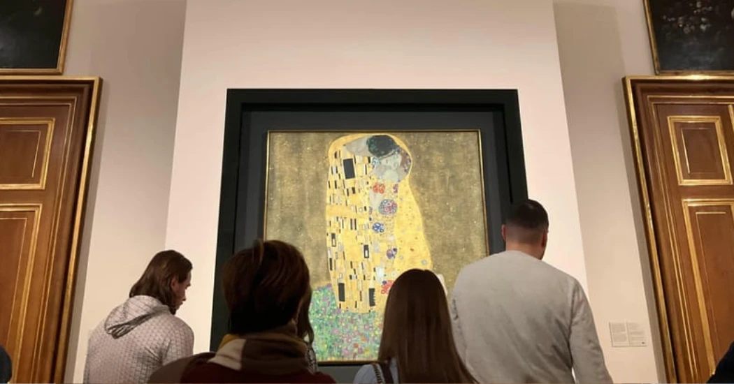 Tourists inside the Belvedere Palace admiring "The Kiss" painting by Klimt.