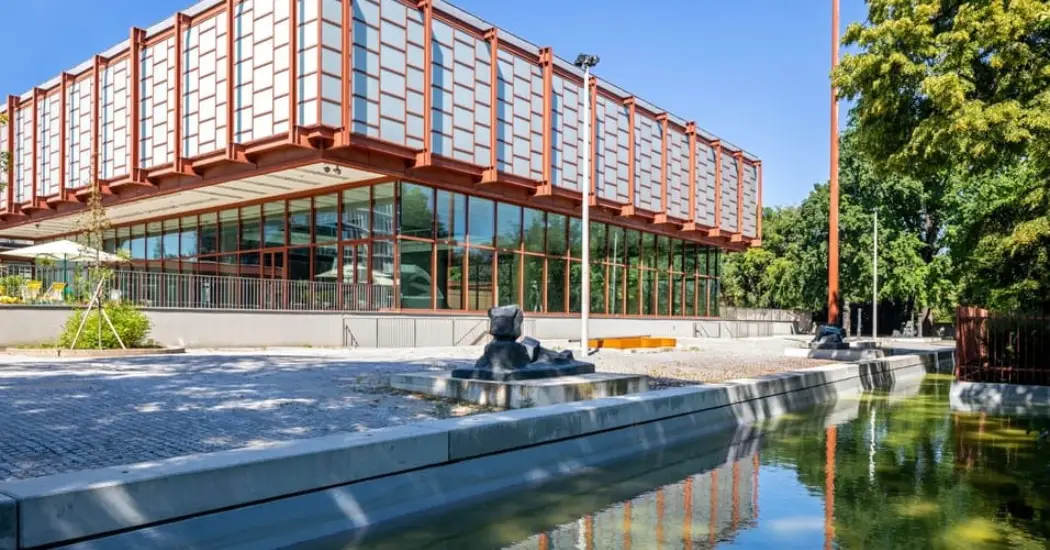 Modern building of Belvedere 21 museum with water canal in front.