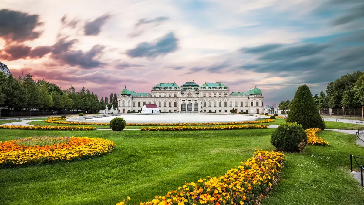 Belvedere Palace in Vienna with a large garden and colorful flowers in front. Belvedere Palace in Vienna with a large garden and colorful flowers in front.