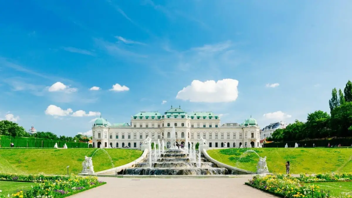 The view of the Belvedere Palace and garden fountains with a clear sky background. The view of the Belvedere Palace and garden fountains with a clear sky background.