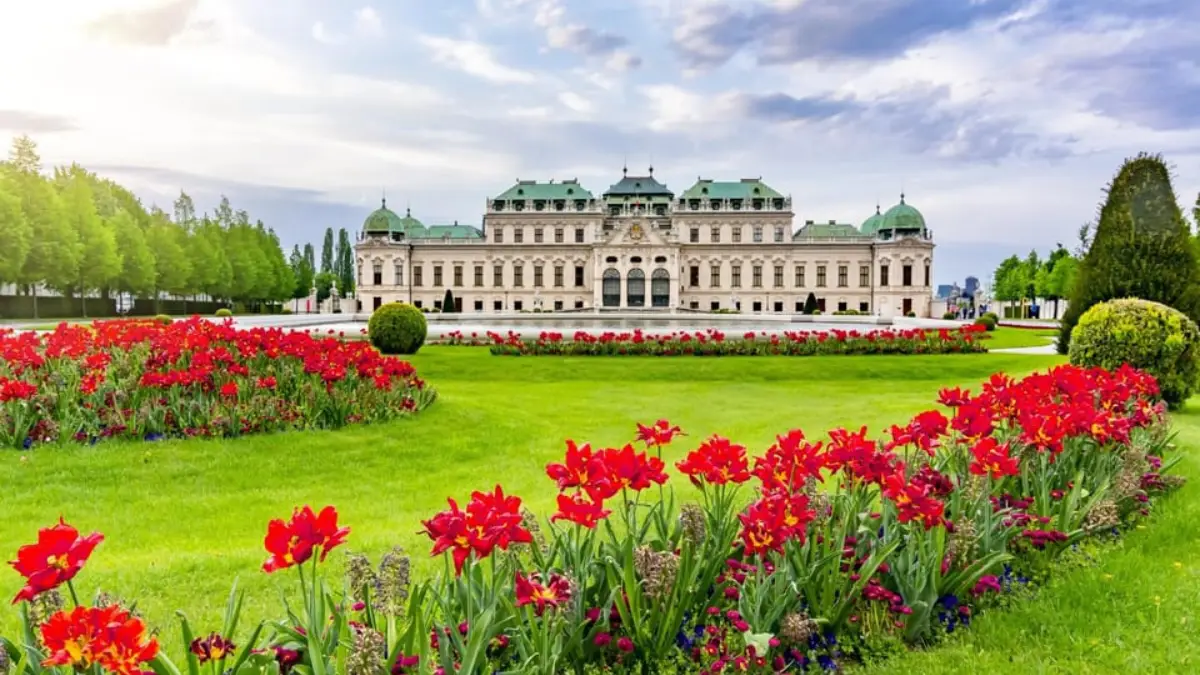 Gardens with red tulips bloom in front of the Upper Belvedere Palace.