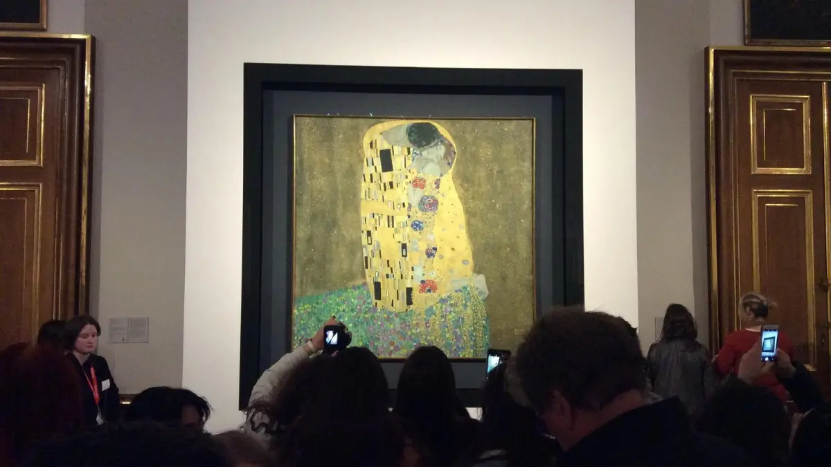 Tourists capturing the iconic gold background painting by Klimt, “The Kiss”. Tourists capturing the iconic gold background painting by Klimt, “The Kiss”.