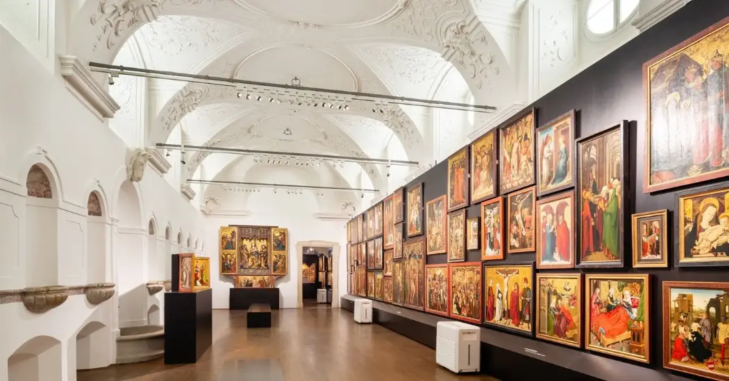 A gallery room inside the Lower Belvedere in Vienna, where walls are filled with historical paintings.