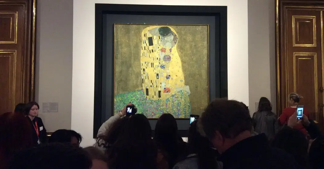 Tourists capturing the iconic gold background painting by Klimt, “The Kiss”.