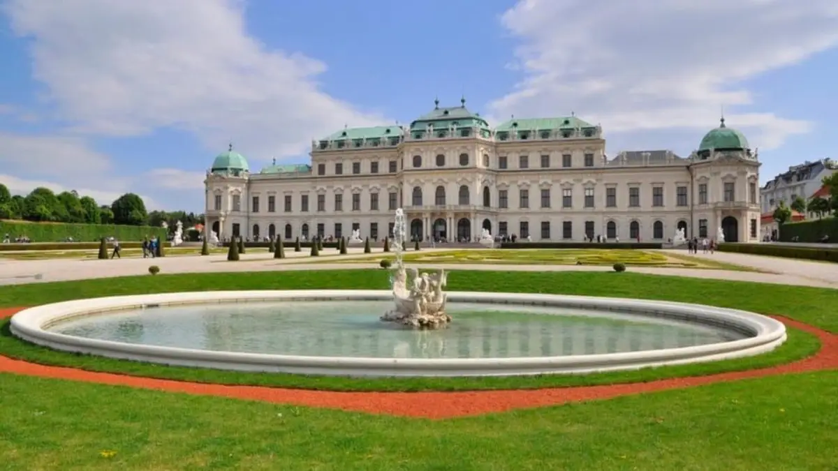Front view of Upper Belvedere Palace with a round fountain and green garden Front view of Upper Belvedere Palace with a round fountain and green garden
