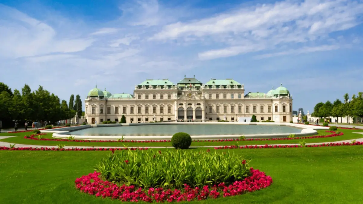 Upper Belvedere Palace with a fountain and colorful garden in front.