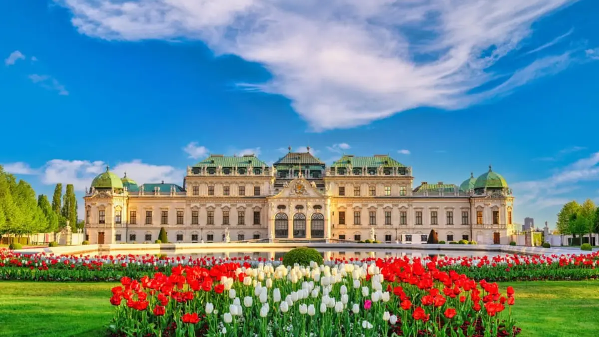 Beautiful front view of Belvedere Palace in Vienna with manicured gardens and a vibrant blue sky. Beautiful front view of Belvedere Palace in Vienna with manicured gardens and a vibrant blue sky.